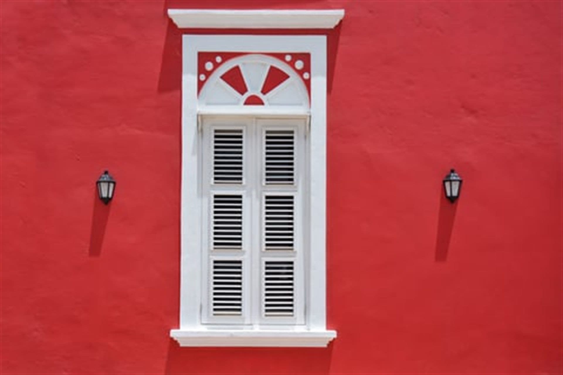 Freshly painted red exterior wall with crisp white window trim in Omaha